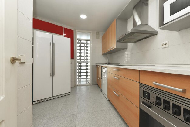 Cocina con gabinetes blancos y encimeras color madera con electrodomésticos blancos y molduras de azulejos