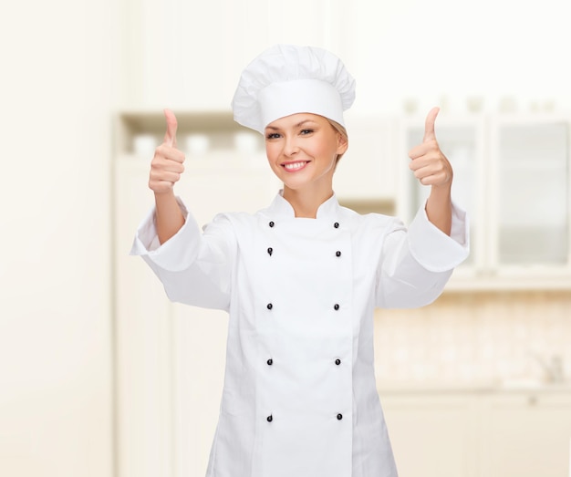 cocina, gesto y concepto de comida - chef, cocinera o panadera sonriente mostrando los pulgares hacia arriba