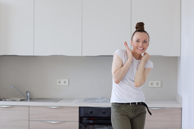 Foto cocina instalada en un piso nuevo y joven ama de casa al frente