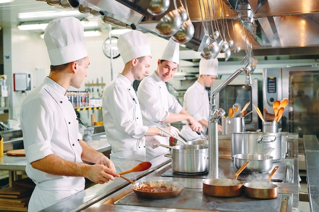 Cocina moderna. Los cocineros preparan las comidas en la estufa en la cocina del restaurante o del hotel. El fuego en la cocina.