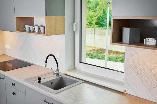 Cocina moderna con fregadero y ventana de fondo de cocina vacía con encimera de madera e ind.