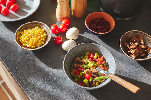 Cocina moderna soleada con plato de quinoa relleno de verduras e ingredientes en la encimera