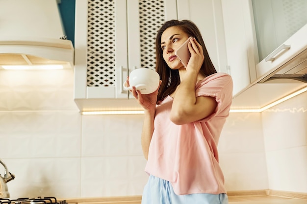 En la cocina Mujer joven descansando y pasando el fin de semana en casa sola en casa