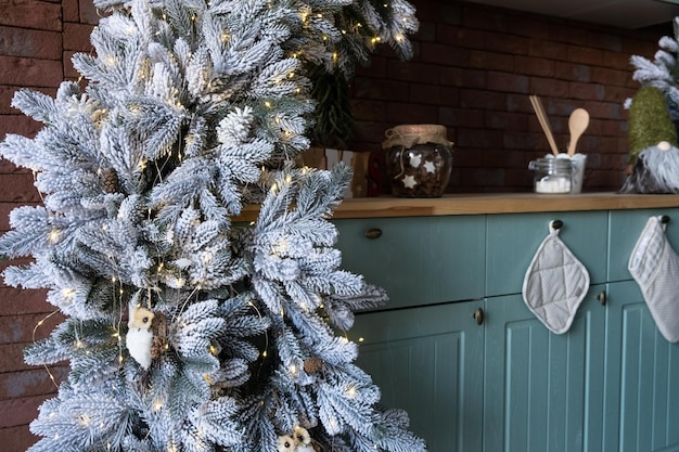 Foto cocina navideña por la tarde decorada con un árbol y guirnaldas.