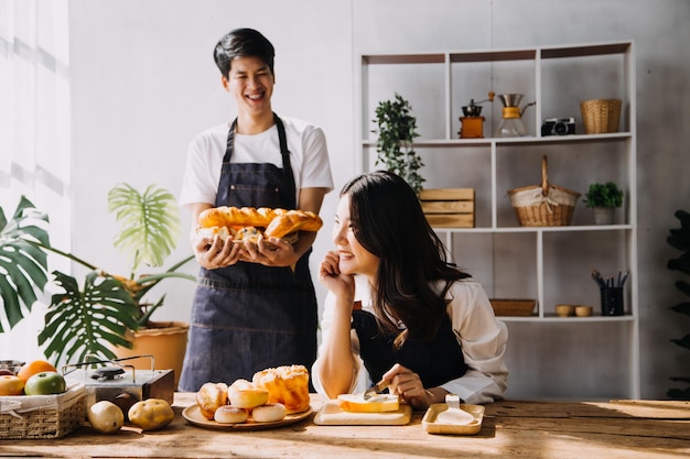 En la cocina Una pareja perfectamente feliz preparando comida saludable Muchas verduras El hombre hace malabarismos con frutas Hace reír a su novia Gente encantadora enamorada Diviértete