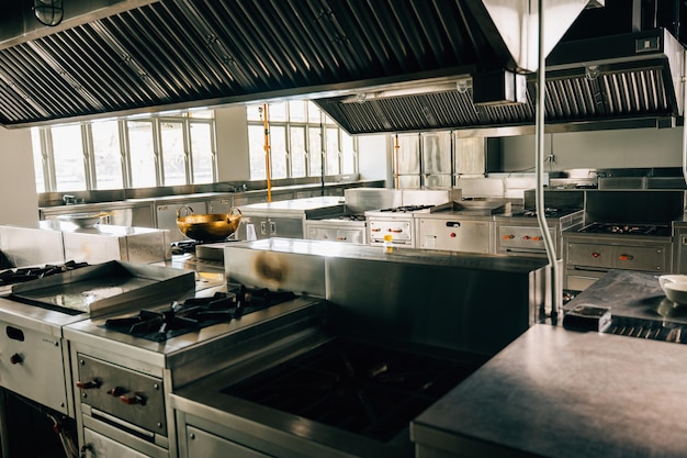 La cocina profesional en el restaurante moderno muestra un cuenco de metal brillante en la estufa arreglo limpio de