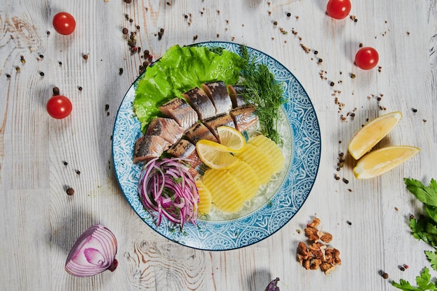 Cocina rusa en forma de patatas con eneldo y arenque en un primer plano de plato blanco Patatas con arenque picado y cebollas espacio de copia