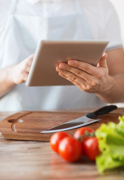 cocina, tecnología y concepto de hogar - cierre del hombre señalando con el dedo a la computadora de tablet pc