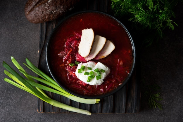 Cocina tradicional ucraniana - borscht con crema agria y cebollas verdes, vista superior