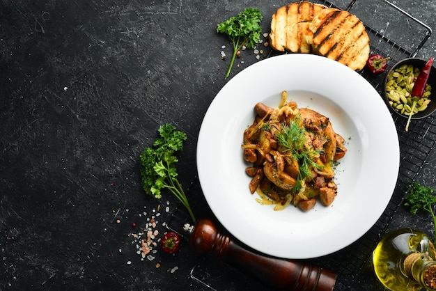 Cocina tradicional ucraniana Patatas fritas con carne, champiñones, cebollas y ajo en un plato Vista superior