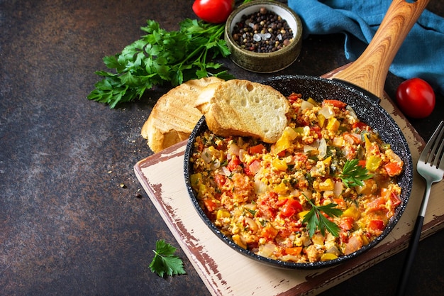 Cocina turca Menemen huevos revueltos en una sartén de hierro fundido sobre una encimera de piedra Copie el espacio