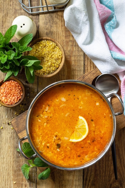 Cocina turca Sopa tradicional con lentejas de arroz y menta en una mesa rústica Vista superior plana