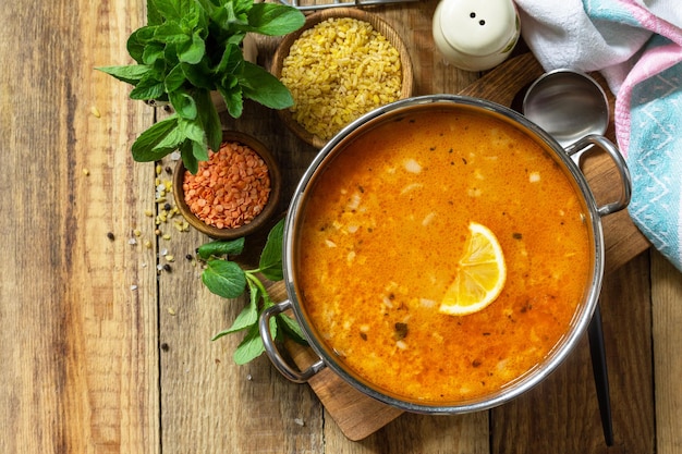 Cocina turca Sopa tradicional con lentejas de arroz y menta en una mesa rústica Vista superior plana