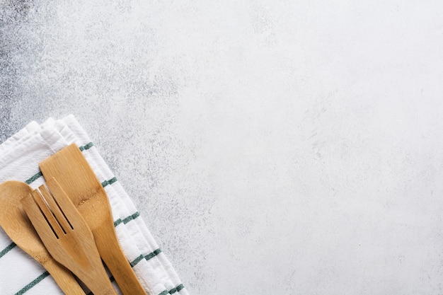Cocina utensilios de bambú tenedor y cuchara sobre una servilleta de lino en un viejo hormigón gris