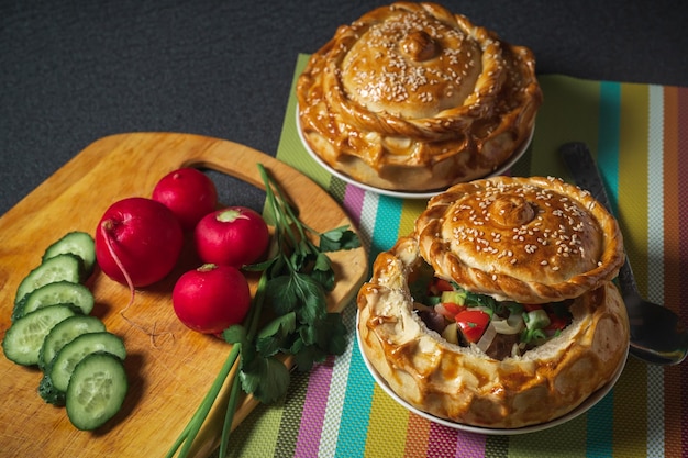 Cocina uzbeka samsa chorba decorada con rábanos rojos de cebolla verde y pepino en rodajas