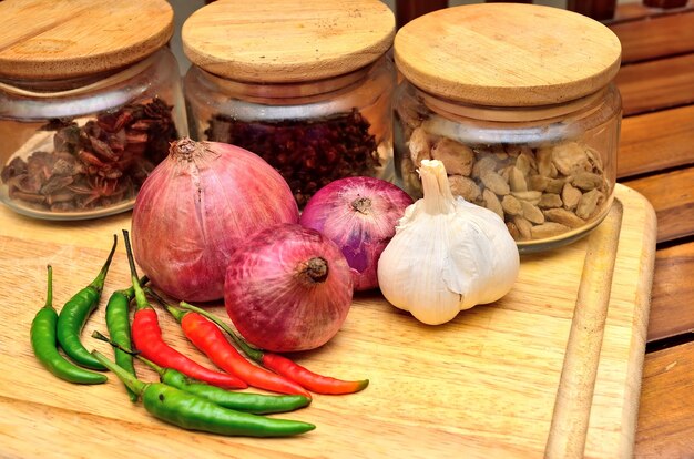 Cocinando ingredientes. Especias y hierbas con cebolla y ajo sobre tabla de madera