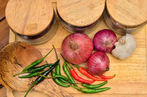 Cocinando ingredientes. especias y hierbas con cebolla y ajo sobre tabla de madera