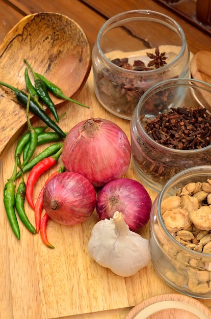 Cocinando ingredientes. Especias y hierbas con cebolla y ajo sobre tabla de madera