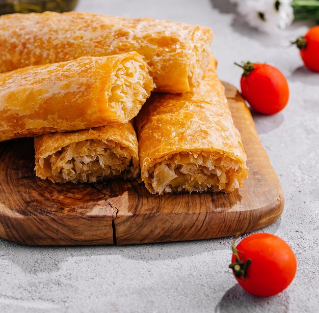 Cocinando pasteles tradicionales con patatas en una mesa de madera