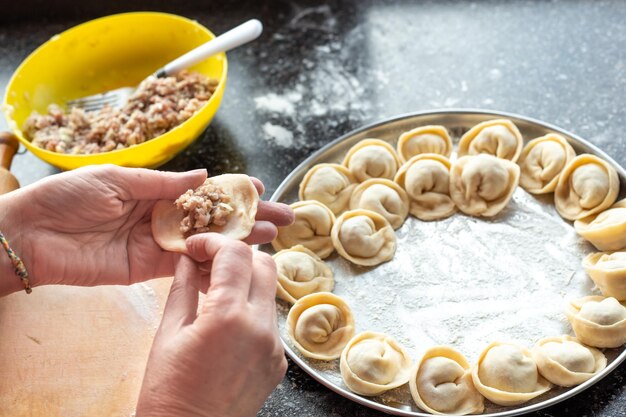 Cocinar albóndigas caseras La mujer llena la masa con relleno