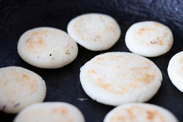 Cocinar las arepas en la sartén.