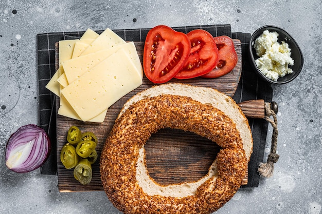 Cocinar Bagels Sándwiches con queso crema jamón tomate y rúcula verde Fondo gris Vista superior