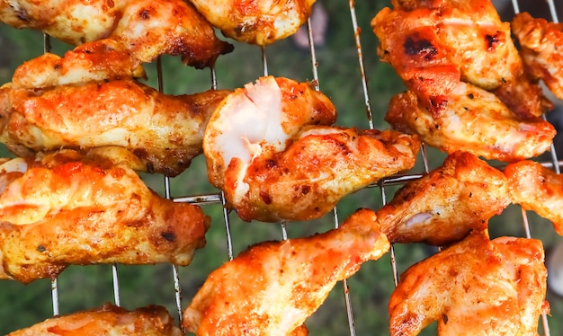 Cocinar brochetas de pollo a la parrilla en el jardín al atardecer