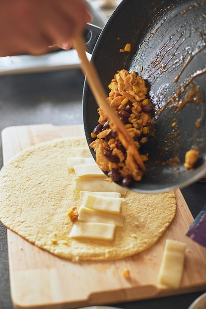 Cocinar burrito comida mexicana en casa tortilla de trigo a la parrilla rellena con queso pollo frijoles maíz l