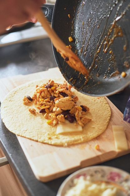 Cocinar burrito comida mexicana en casa tortilla de trigo a la parrilla rellena con queso pollo frijoles maíz l