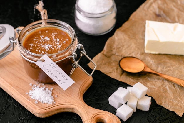 Cocinar caramelo salado. Ingredientes para caramelo. Caramelo salado en un frasco.