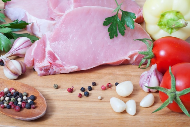 Cocinar carne de cerdo con verduras en tablero de madera