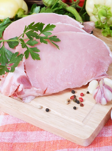 Cocinar carne de cerdo con verduras en tablero de madera