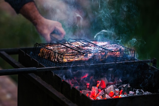 Cocinar carne sobre brasas en la parrilla