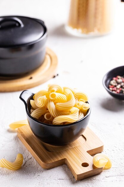 Cocinar la cena con plato de pasta de fusilli crudo