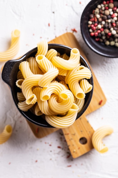 Cocinar la cena con plato de pasta de fusilli crudo