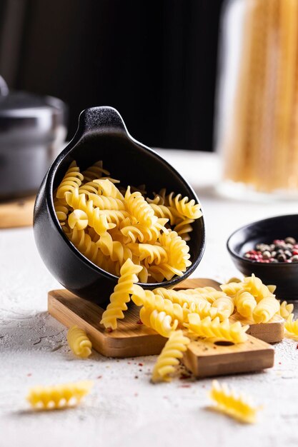 Cocinar la cena con plato de pasta de fusilli crudo