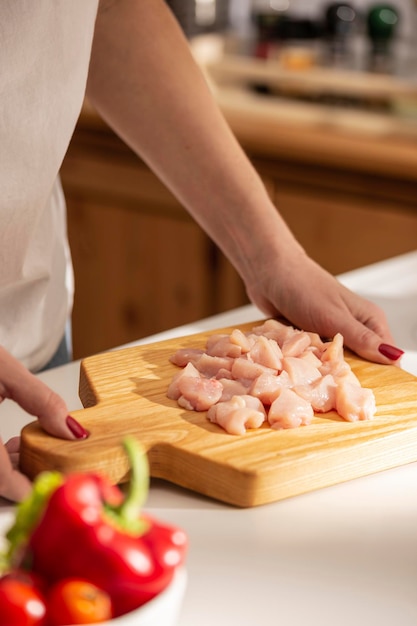 Cocinar la cena con pollo en una cocina.