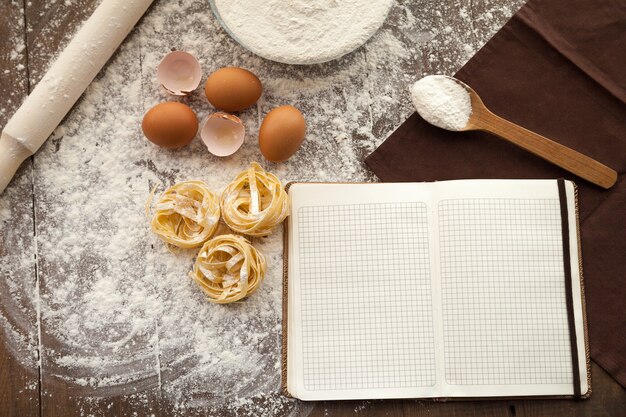 Foto cocinar una comida sabrosa y escribir la receta en nota abierta.