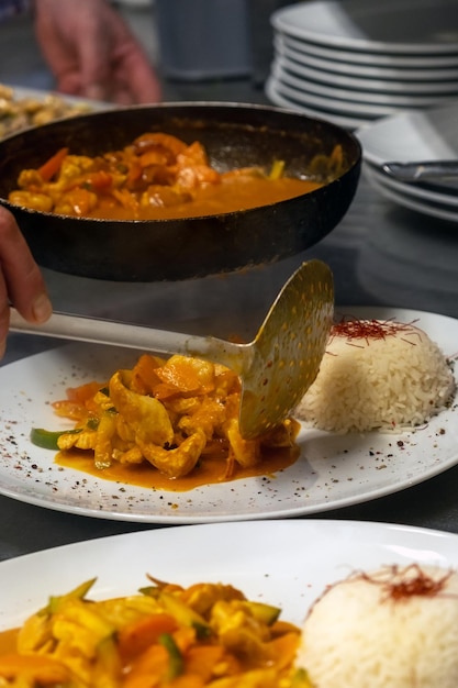 Foto cocinar curry rojo con mariscos, pollo y arroz.
