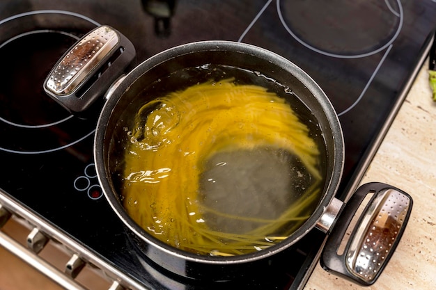 Cocinar deliciosos espaguetis en agua hirviendo