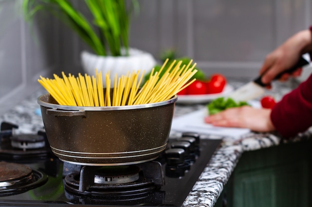 Foto cocinar espagueti en una cacerola en una cocina en casa