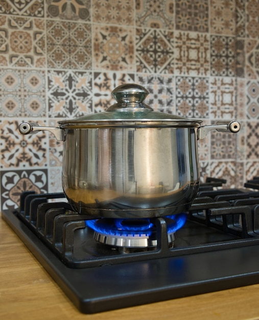 Cocinar en una estufa de gas. La olla en el quemador de gas. Concepto de cocina casera.