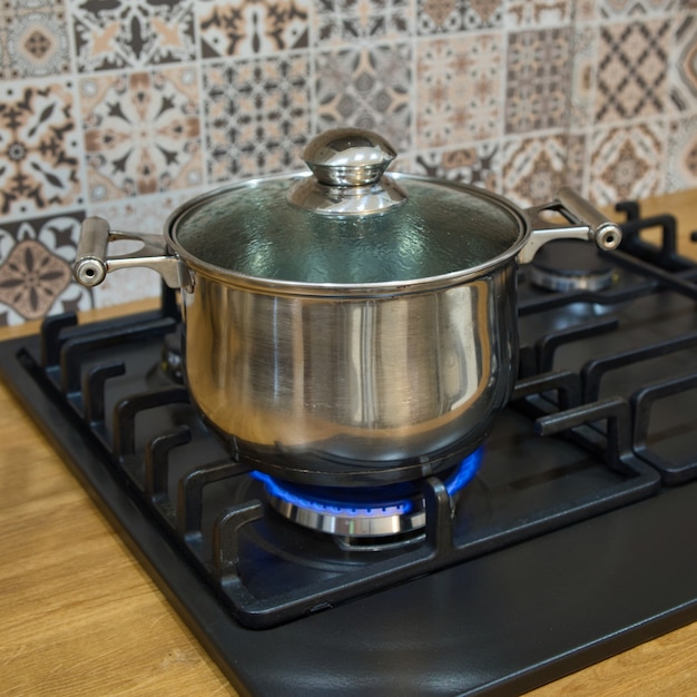 Cocinar en una estufa de gas. La olla en el quemador de gas. Concepto de cocina casera.