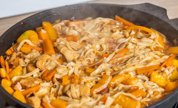 Cocinar fideos udon en una sartén