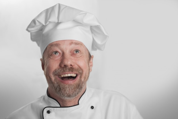 Cocinar en la gorra blanca se ríe