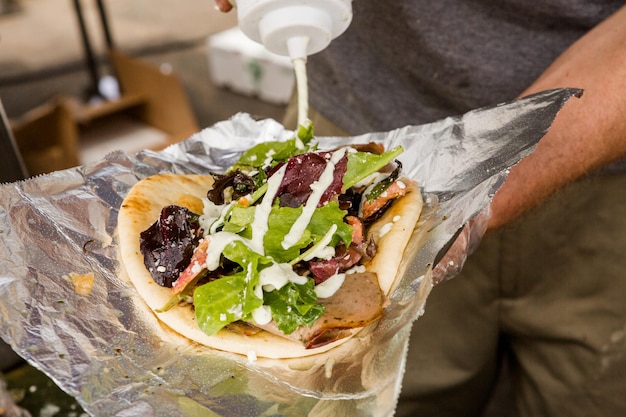 Cocinar gyros griegos en el mercado de agricultores.