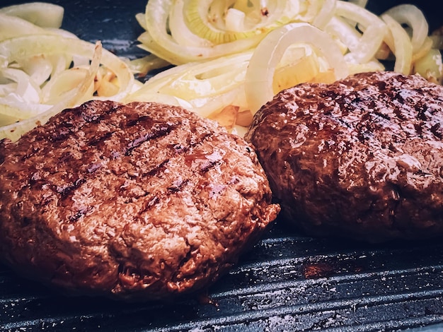 Cocinar hamburguesa de ternera picada en una sartén de parrilla de hierro fundido al aire libre carne roja en una sartén asar comida en el jardín Vivir en la campiña inglesa