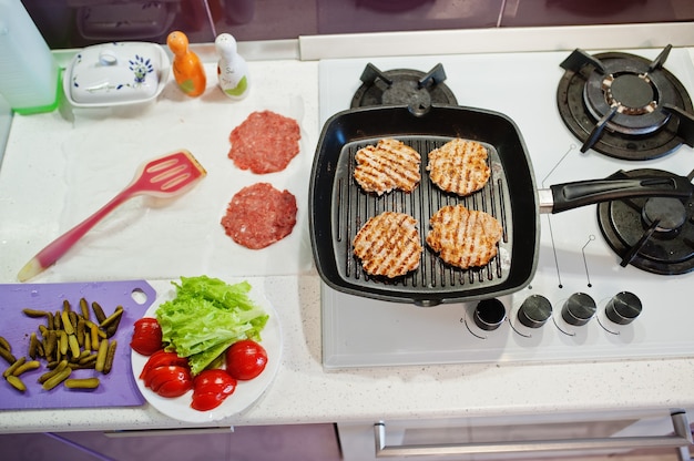 Ð¡Cocinar hamburguesas en la cocina de casa durante el tiempo de cuarentena.