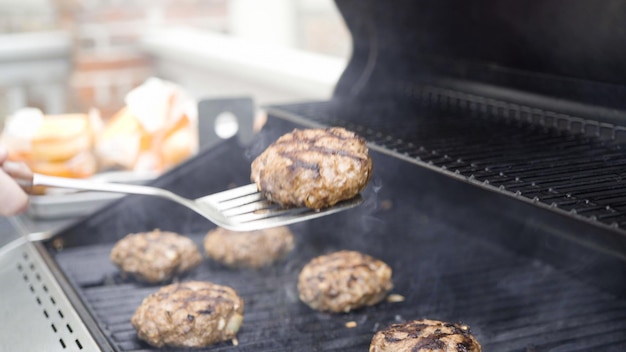 Cocinar hamburguesas de ternera en una parrilla de gas.