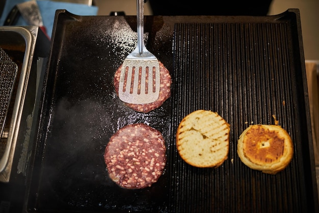 Cocinar hamburguesas de ternera en una superficie para freír. hamburguesas